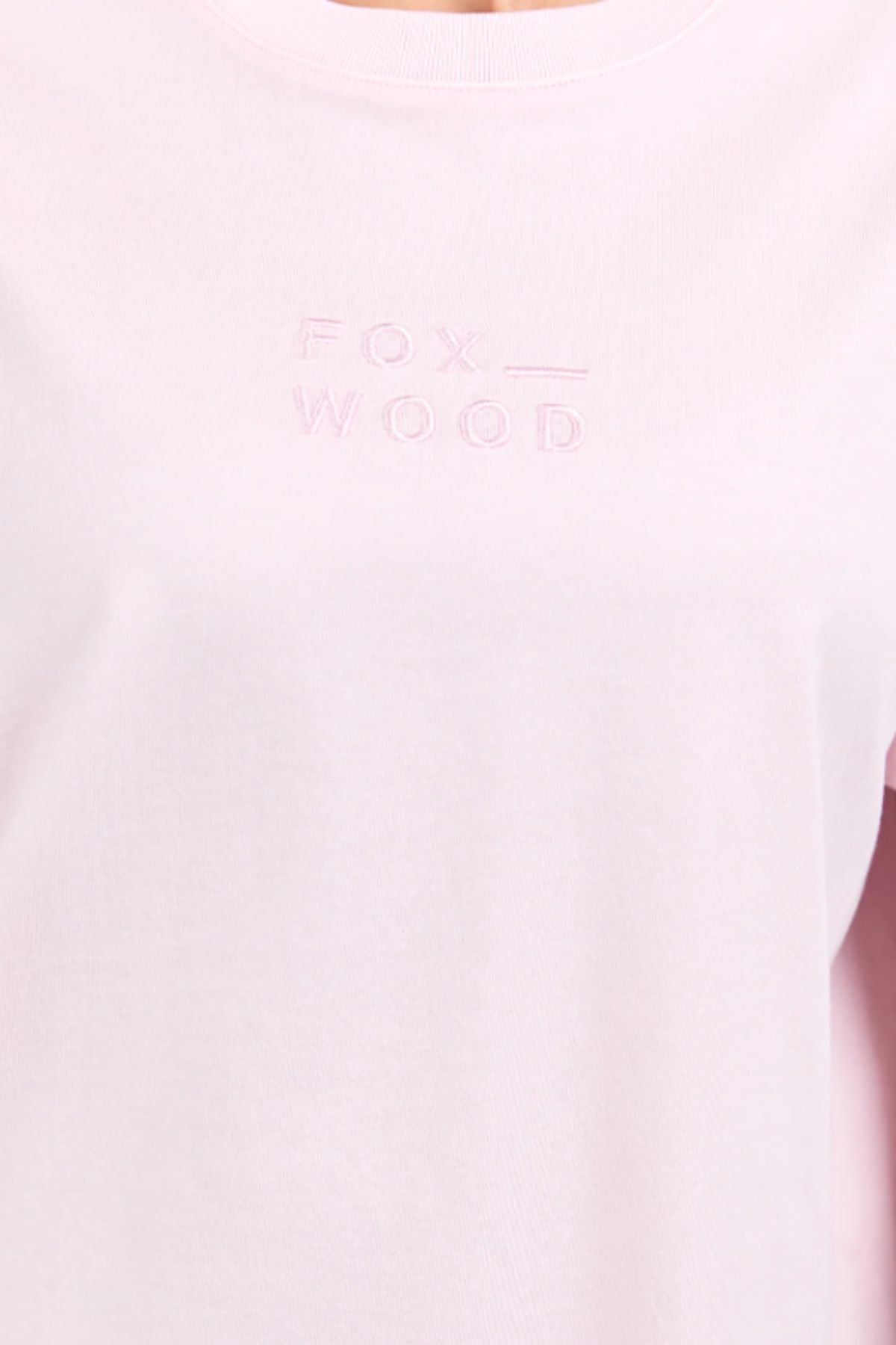 Close-up of the Foxwood Huntleigh Oversized Tee in light pink, showcasing "FOX WOOD" embroidery on the chest. This premium cotton tee combines comfort and style in an oversized fit.