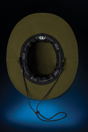 The FXD CP-14 Boonie Hat is an olive green wide-brim boonie with a black chin strap and "FXD FUNCTION BY DESIGN" label, shown from above on a dark background with a blue spotlight—perfect for outdoor work and sun protection.