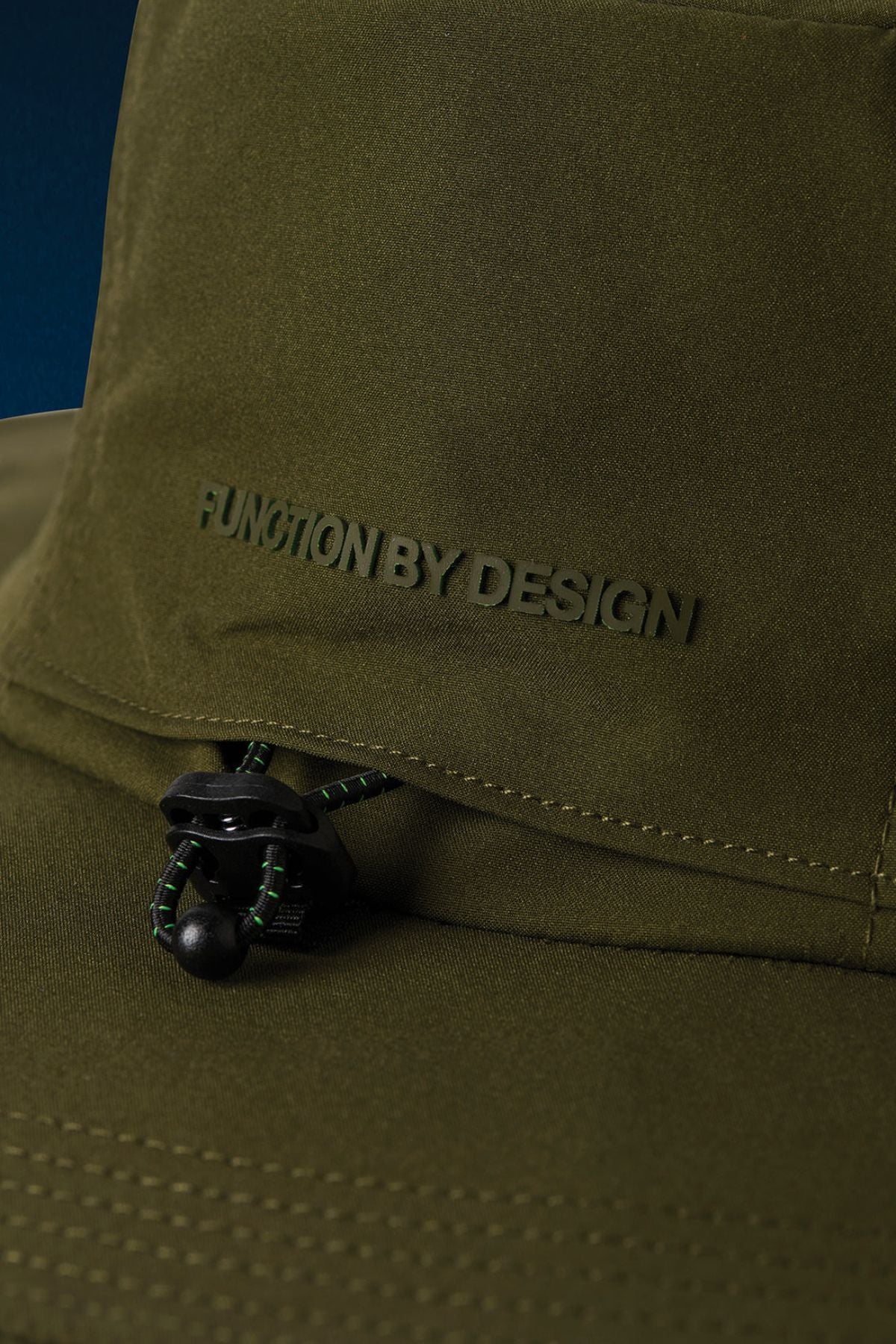 Close-up of the FXD CP-14 Boonie Hat in olive green, featuring "FUNCTION BY DESIGN" embossed on the front and a black adjustable drawstring with green accents—ideal for sun protection during outdoor work.