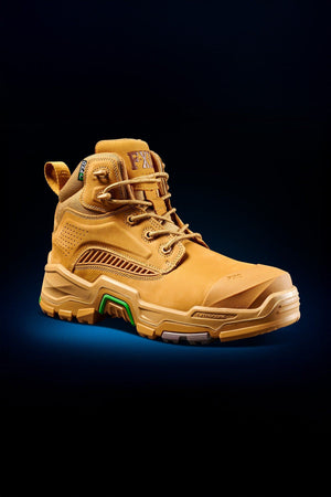 The FXD Dura X-2 Nitrocore™ Mid Cut High Performance Work Boots feature a tan high-top design with rugged tread, detailed stitching, reinforced toe and heel, plus green accents—all set against a dark gradient background.