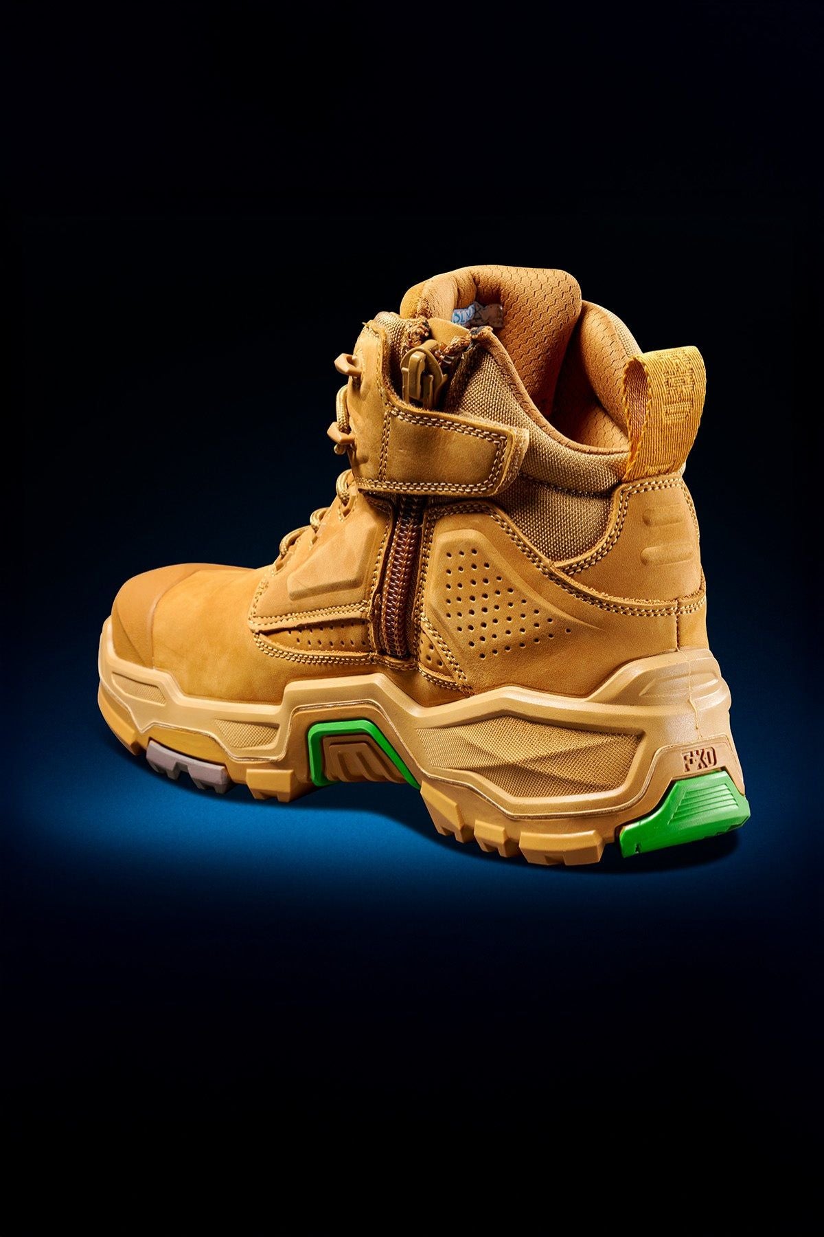 The FXD Dura X-2 Nitrocore™ Mid Cut High Performance Work Boots feature a tan design with rugged soles, ankle support, a side zipper, and green heel accents, shown against a dark background.