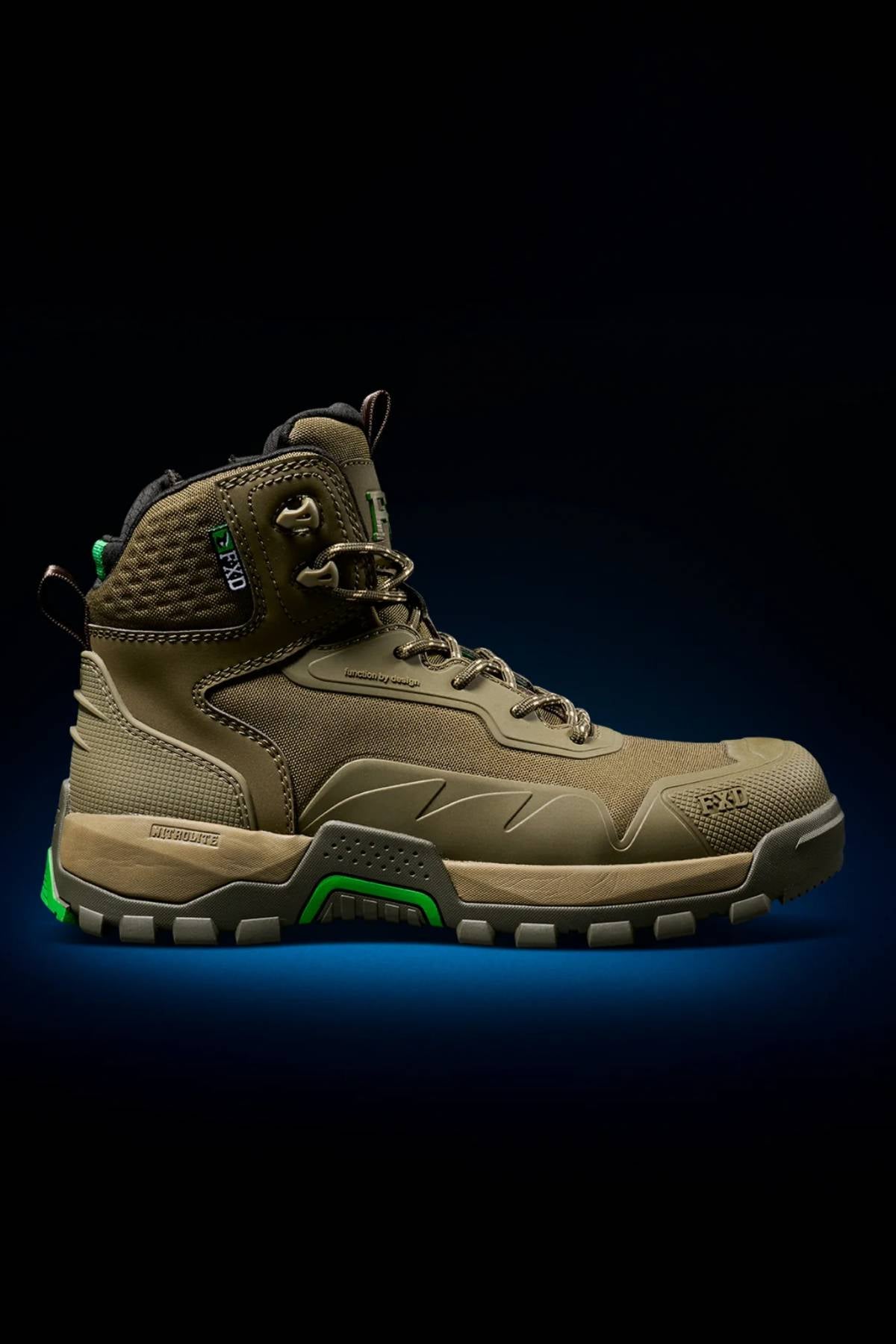 The FXD WB-6 Work Boot features a brown and green durable synthetic upper with a thick, textured sole. Shown in profile against a black background with a blue glow beneath the shoe.