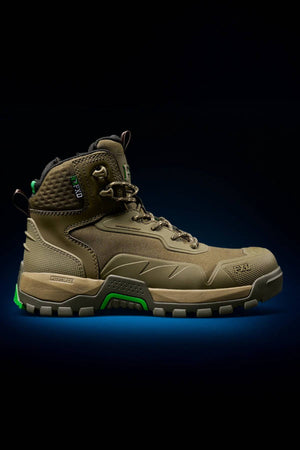 The FXD WB-6 Work Boot features a brown and green durable synthetic upper with a thick, textured sole. Shown in profile against a black background with a blue glow beneath the shoe.