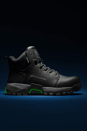 Introducing the FXD WB-3 Work Boot: A sleek black high-top crafted from premium leather, featuring green accents that stand out on its dark background. This stylish shoe is equipped with black laces, a rugged sole, and a convenient loop on the heel, blending the elegance of a sneaker with robust work boot elements.