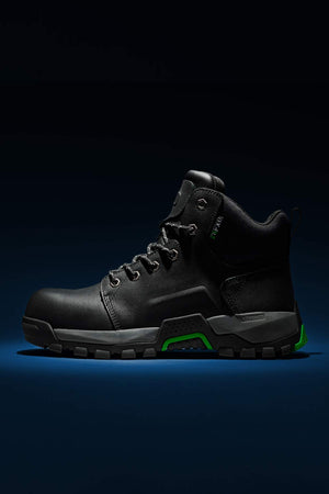 The FXD WB-3 Work Boot, crafted from premium leather in black with green accents, showcases a rugged sole designed for durability and comfort. Displayed against a dark background, the boot's side profile highlights its robust safety toe.