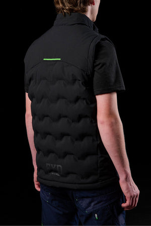 A person is seen from the back in a black shirt and the FXD WO-6 Insulated Puffer Vest, which features water repellent fabric, visible stitching, and a subtle green accent, all set against a black background.