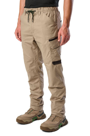A person wearing FXD WP-12 work pants featuring a drawstring waist, black-trimmed utility pockets, and brown hiking boots, with the photo cropped at the waist and ankles.