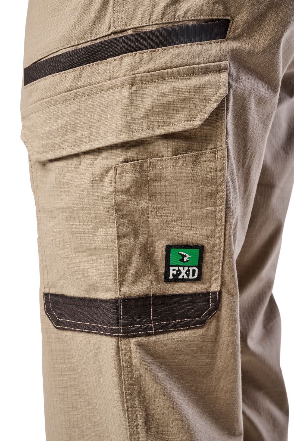 Close-up of the side utility pocket on FXD WP-12 light brown work pants with dark brown trim, white stitching, and a green and black FXD logo patch.