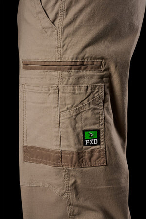 Close-up of FXD WP-3L Loose Fit Stretch Canvas Work Pants in tan, showcasing multiple pockets, visible stitching, and a green and black FXD logo tag on the pocket.