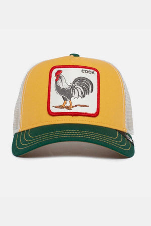 Goorin Bros The Cock Cap is a yellow and green trucker hat with a white mesh back, featuring a front patch of a rooster and "COCK" in the top right, merging classic style and bold humor.