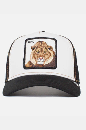 The Goorin Bros The King Lion Cap is a black and white trucker cap featuring an embroidered patch on the front with a lion's face and the word "KING" above it. The crown is white with black stitching, while the bill and mesh back are black.