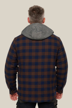 A man faces away from the camera, wearing a Hard Yakka Quilted Flannelette Shacket in brown and navy check with a gray hood, set against a plain light beige background.