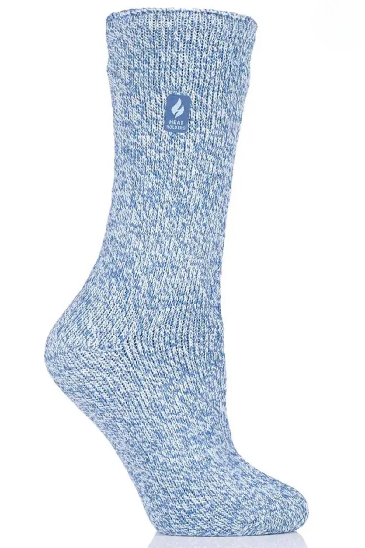 A single Heat Holders Ladies Original Thermal Heat Sock in blue and white marled knit stands upright against a white background, displaying a small blue label with a leaf design near the top.