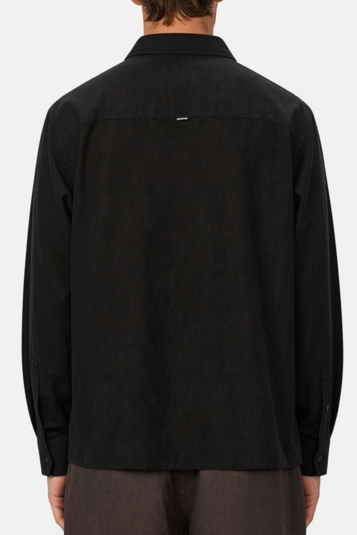 A person is shown from the back against a plain light background, wearing the Industrie The St Martins Shirt in black—a long-sleeve linen shirt with a regular fit—paired with dark pants.