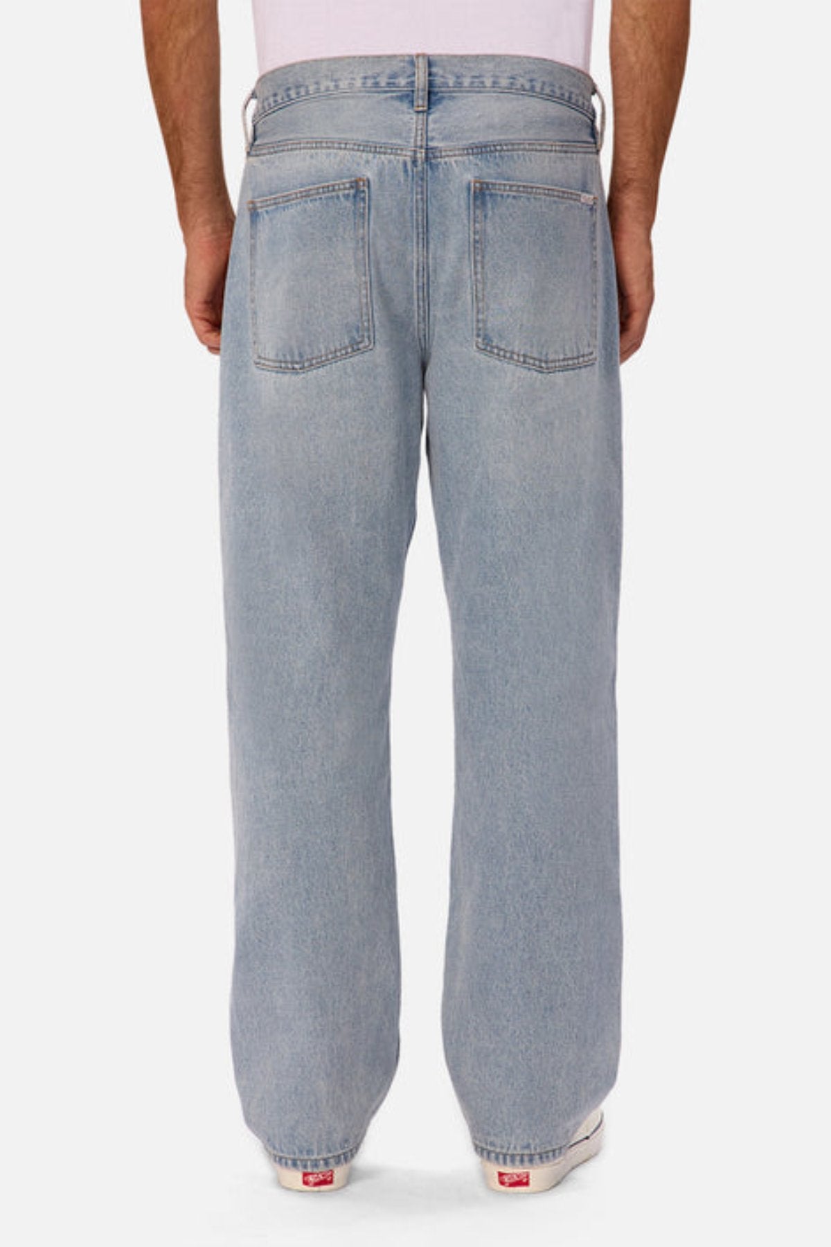 A person wearing Industrie The 90's Jean—vintage washed, light blue, relaxed straight leg, 100% cotton—and a white shirt is shown from the back against a plain white background.