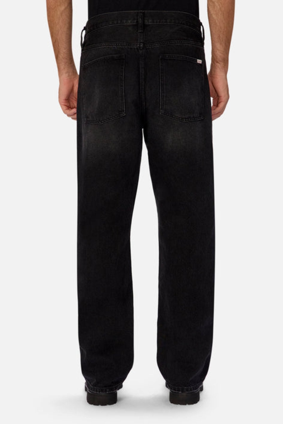A person models Industrie The 90's Jean, vintage washed denim with a relaxed straight leg fit and two back pockets, crafted from 100% cotton, against a plain light background.
