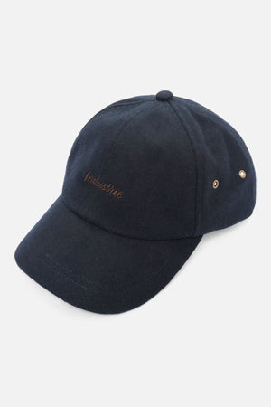 The Industrie The Claude Cap is a stylish black baseball hat with a curved brim, two metal eyelets on the side, and "Innisfree" embroidered in brown on the front. It features an adjustable strap for a comfortable, all-day fit.