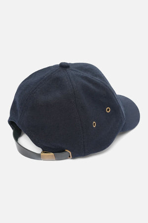 The Industrie The Claude Cap, shown from the back in navy blue, features an adjustable strap with a metal buckle, metal eyelets, and a curved brim—blending timeless design with comfort.