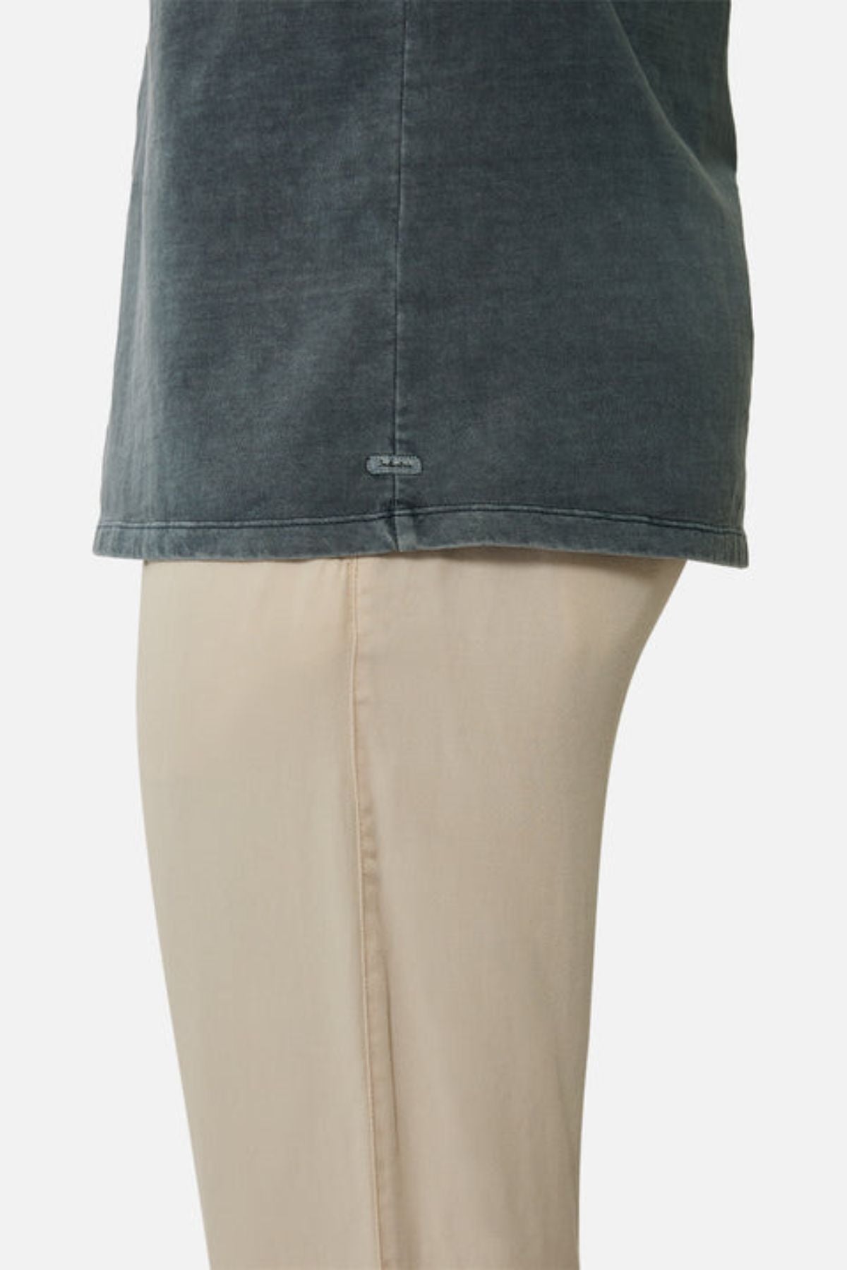 Side view of a person wearing an oversized, faded dark gray Industrie The Del Sur Tee and light beige pants, showing only the torso and upper legs against a plain white background.