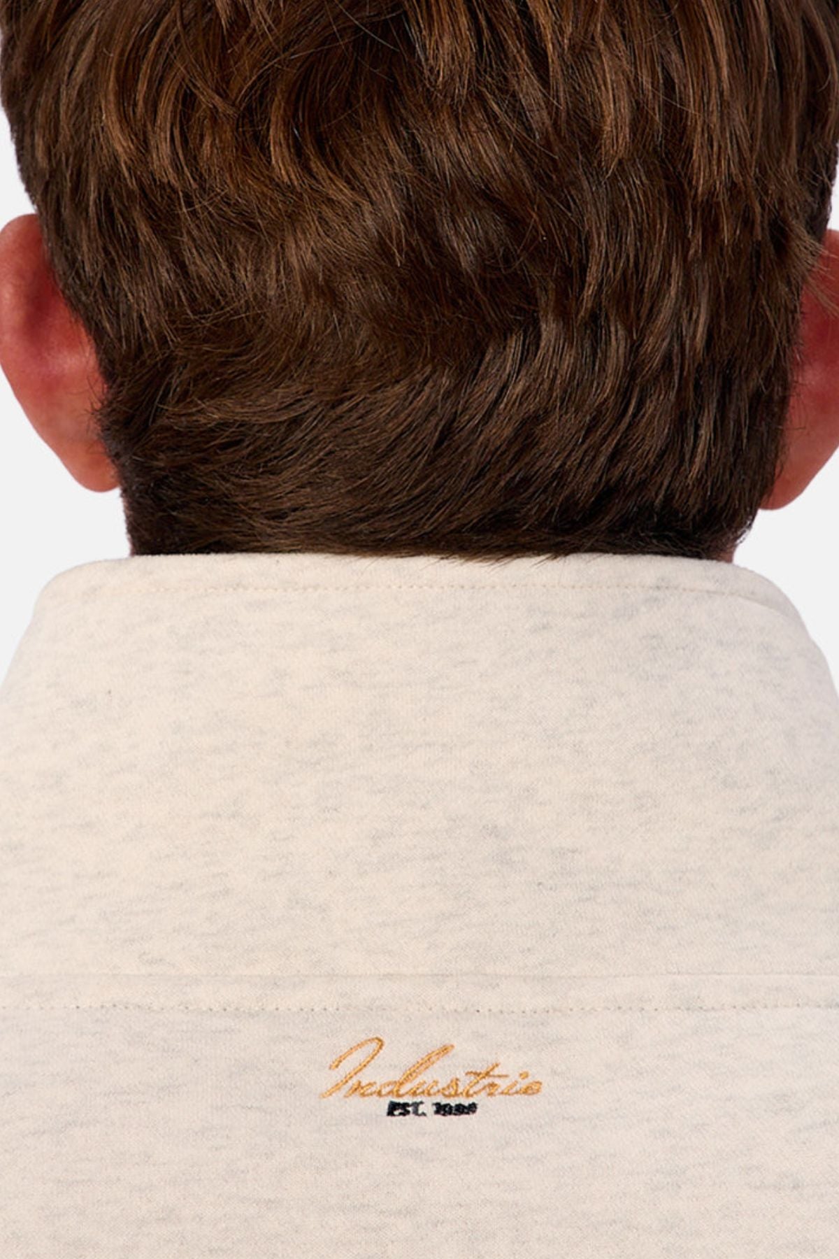 Close-up of the back of a person's head and neck, featuring brown hair and the Industrie The East Village Track Top in light gray with gold and black "Industrie EST. 1999" embroidery on the collar—relaxed fit, ideal for casual wear.