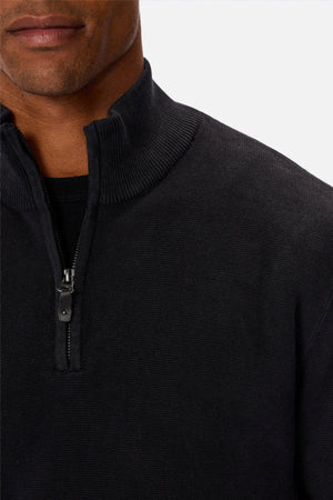 A close-up of a person wearing the Industrie The Lakewood Zip Neck sweater, zipper partially up, showing part of their lower face and neck against a plain light background.
