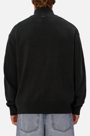 A person is shown from behind wearing the Industrie The Maine Zip Neck Knit in black with light blue denim jeans against a plain, light-colored background.