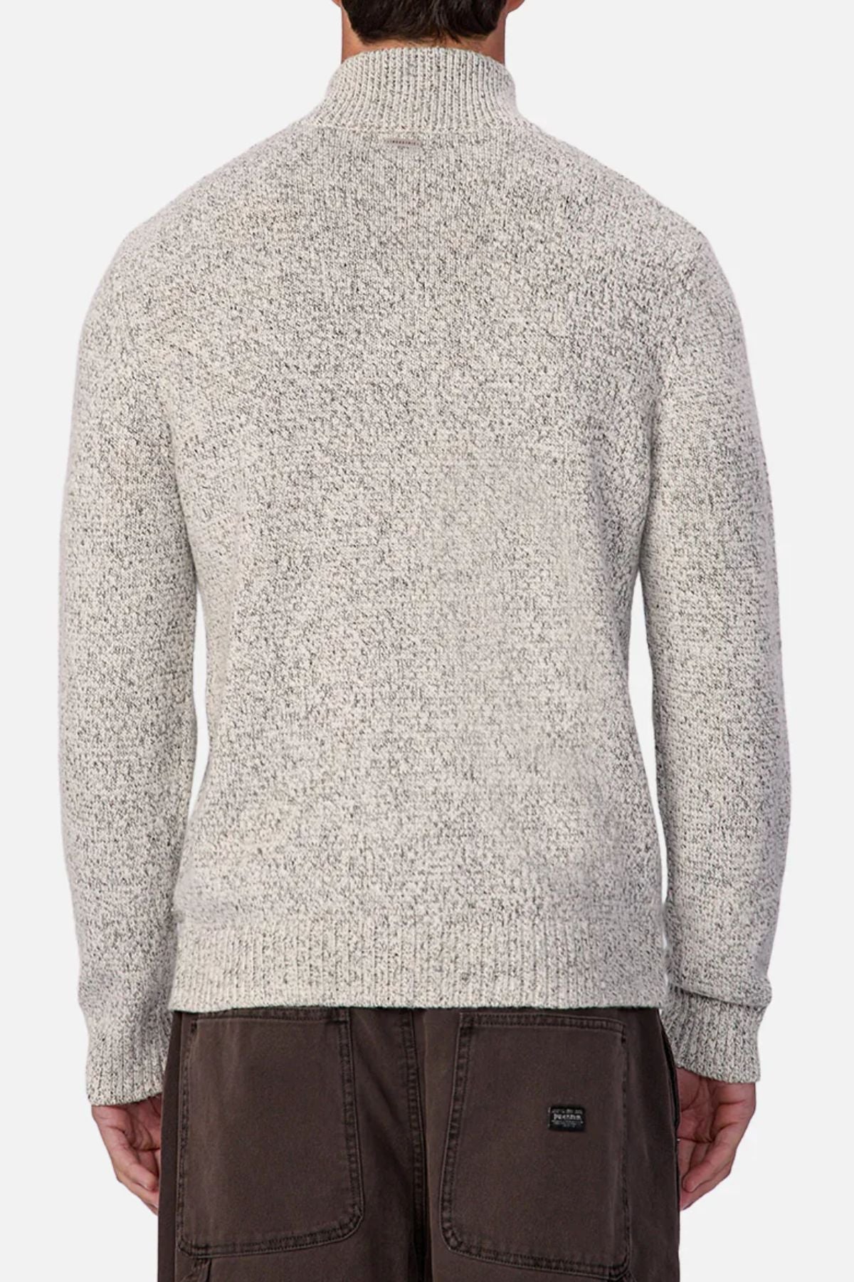A person is seen from behind wearing the Industrie The Montauk Knit in light gray with a zip neck and marled knit texture, paired with dark brown pants against a plain white background.