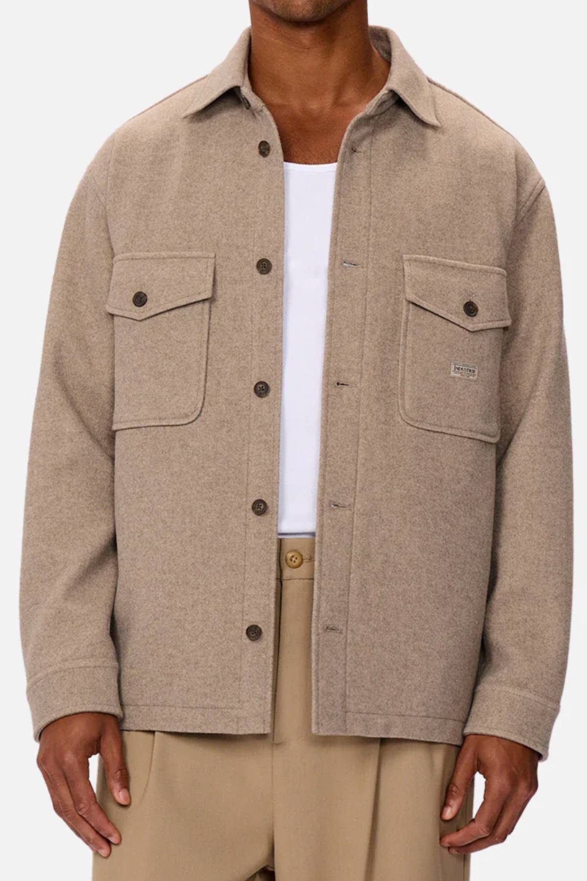 Wearing the Industrie The New Coleman Jacket—a light brown wool shirt jacket with classic collar and twin chest pockets—over a white tee and beige pants, shown from shoulders to mid-thigh.