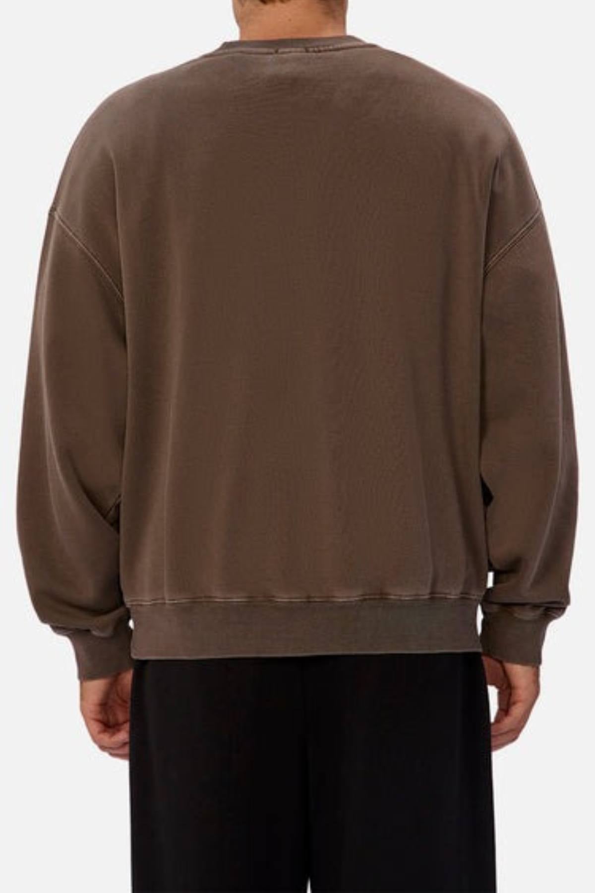 Person wearing an oversized fit, brown Industrie The New Del Sur Washed Sweat with long sleeves and ribbed cuffs and hem, seen from the back against a plain background.