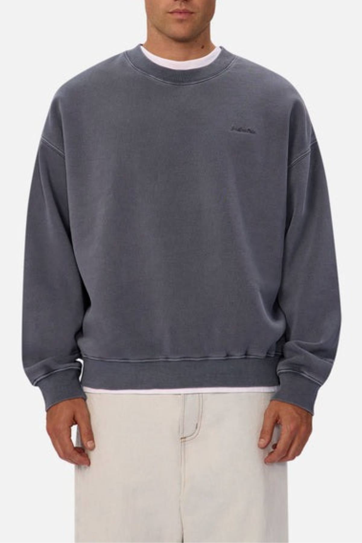 A person wears the oversized Industrie The New Del Sur Washed Sweat in faded gray with a subtle chest logo and light-colored pants, standing against a plain background.