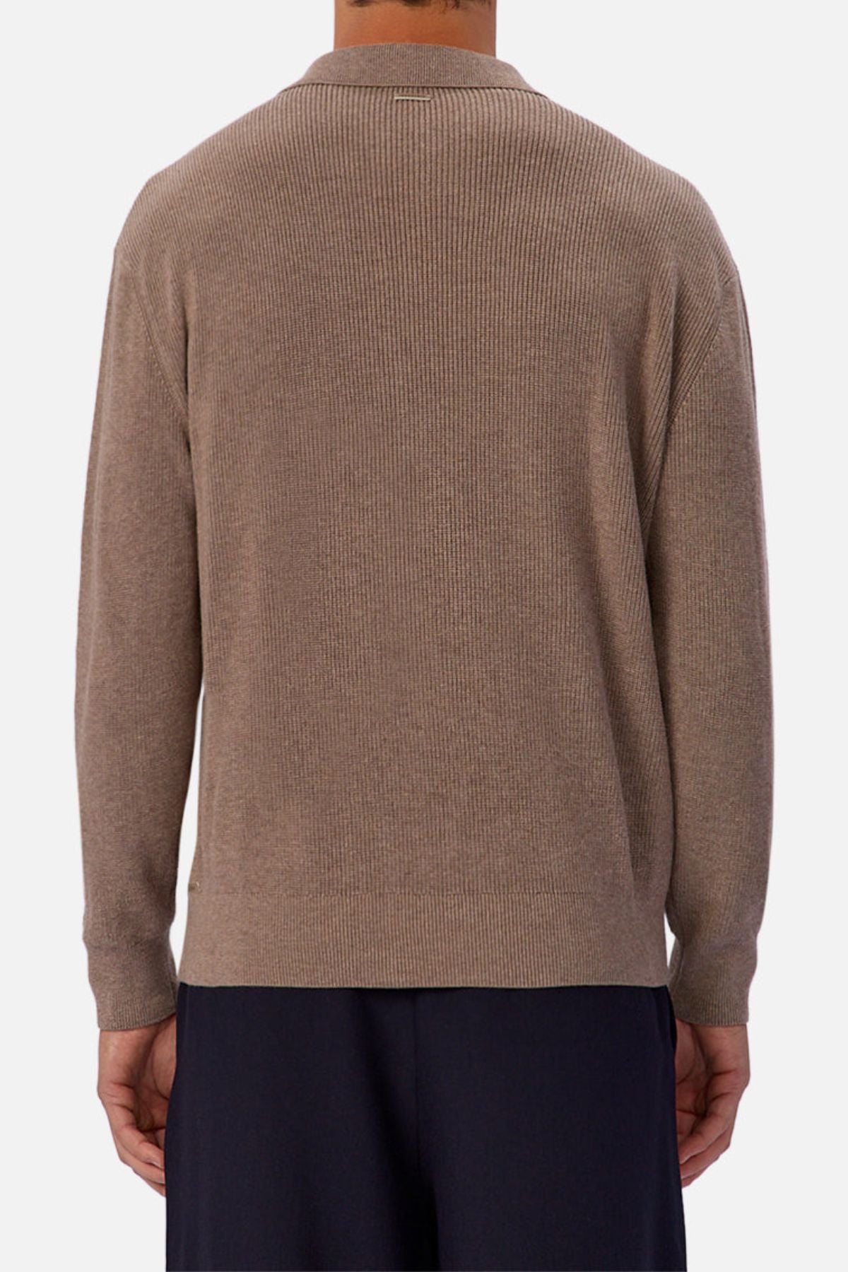 A person is seen from behind wearing the Industrie The New England Polo Knit in light brown with black pants, standing against a plain white background.
