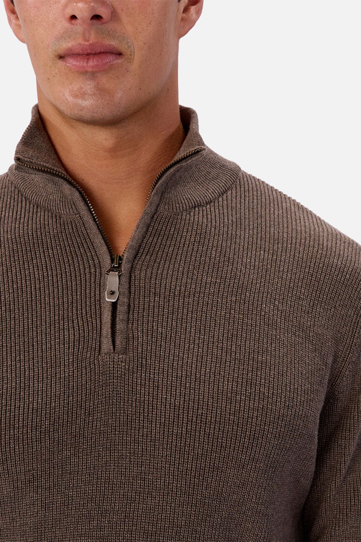 A person wearing the Industrie The New England Zip Neck Knit in brown. The ribbed sweater’s zipper is partially open, with the image cropped to show the lower face, neck, and upper torso.