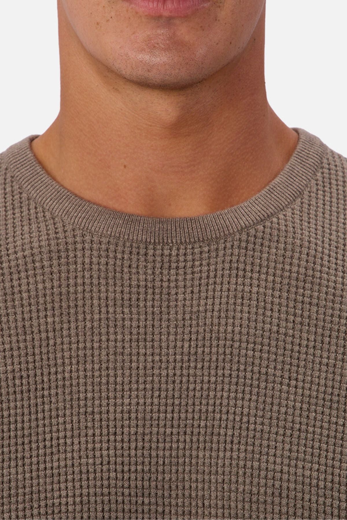 Close-up of a person wearing the Industrie The Philly Waffle Knit in taupe, showing the lower face, neck, and upper chest against a plain background.