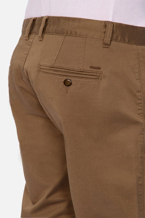 Close-up of the back of a person wearing Industrie The Regular Cuba Chino Pant in light brown with a wide leg fit, buttoned back pocket, belt loops, and a tucked-in light pink or white shirt.