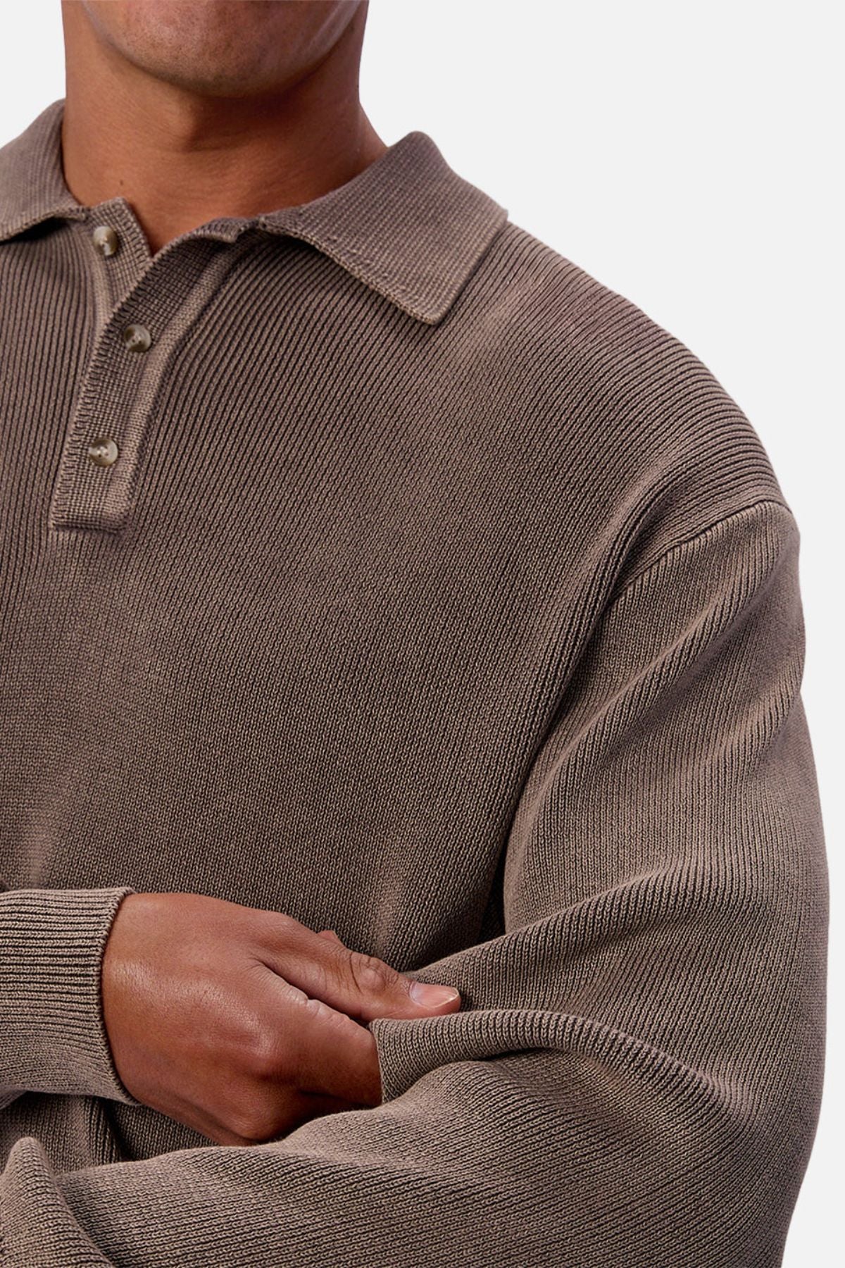 A person in the Industrie The Sawtelle Knit, a textured brown long-sleeve 100% cotton polo shirt, stands with arms crossed against a plain background.