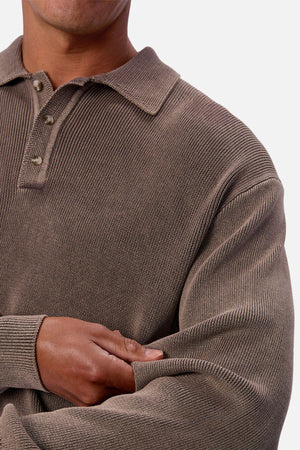 A person in the Industrie The Sawtelle Knit, a textured brown long-sleeve 100% cotton polo shirt, stands with arms crossed against a plain background.