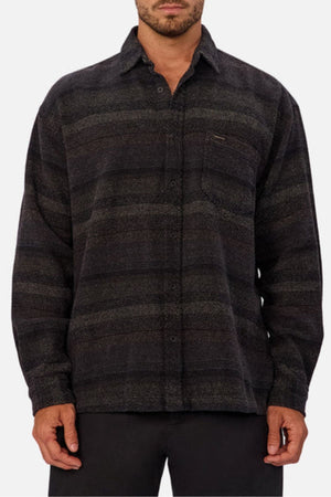 A man models the Industrie The Sonoran Long Sleeve Shirt with a regular fit and subtle shadow pattern, complete with a chest pocket, standing before a simple light background.