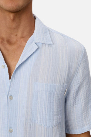 A close-up of a person wearing the Industrie The Striped Seguro Short Sleeve Shirt. Only the lower part of their face, neck, and upper torso are visible.