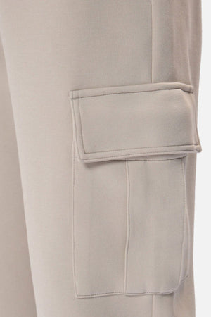 Close-up of Industrie The Tech Combat Trackpant in light beige, featuring a rectangular flap side pocket on the thigh—ideal for those who prioritize style and performance in athletic wear.