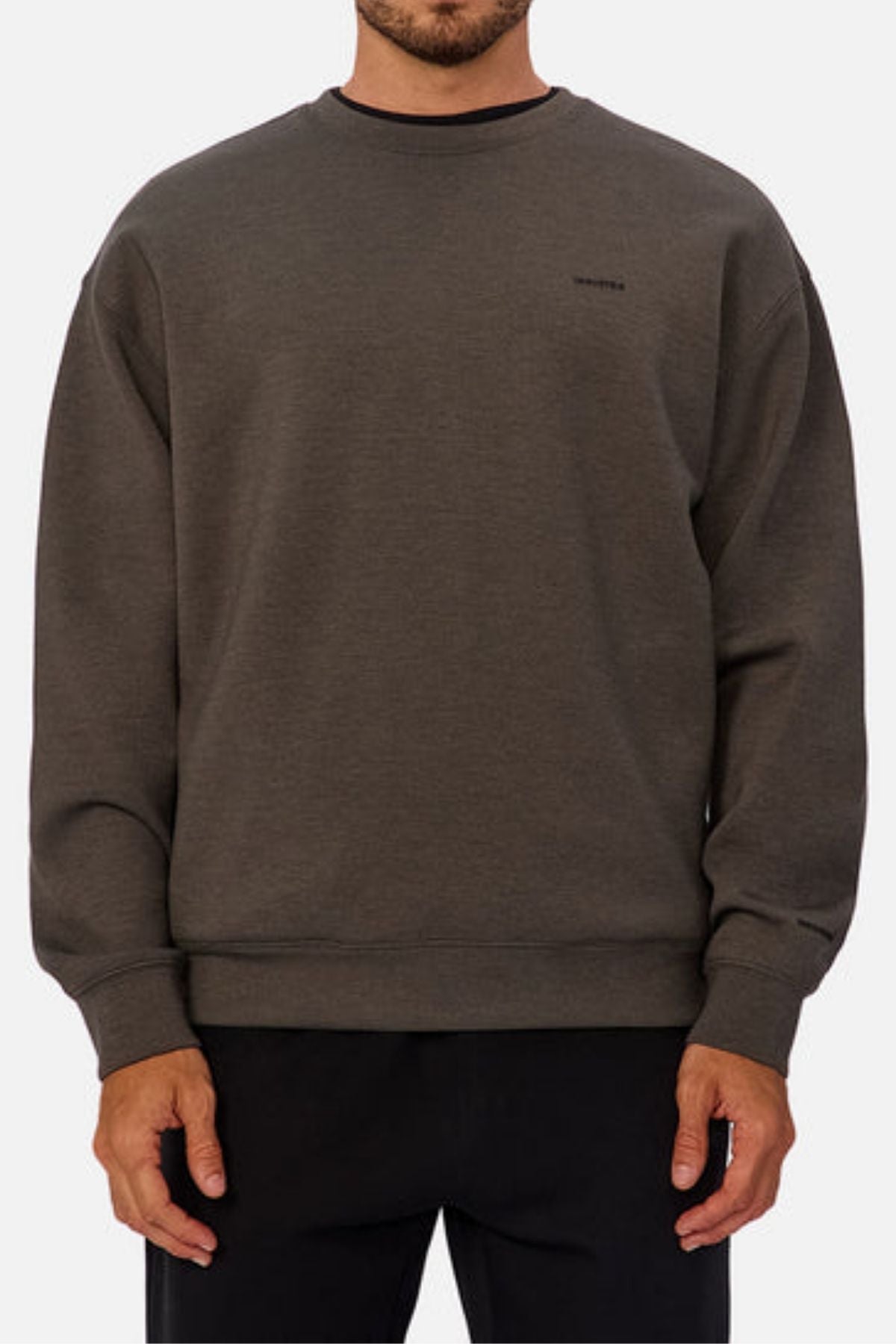 A man faces forward against a light background, showing his torso and arms, wearing the Industrie The Tech Del Sur Sweat—a plain, dark gray crewneck sweatshirt made from breathable fabric—paired with black pants.