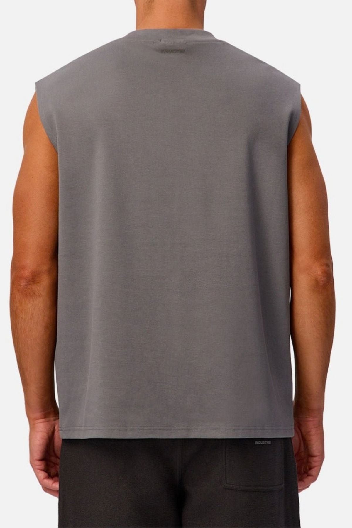 A person is shown from the back against a plain, light background, wearing the Industrie The Tech Port Sleeveless Tee in a relaxed fit with black shorts.