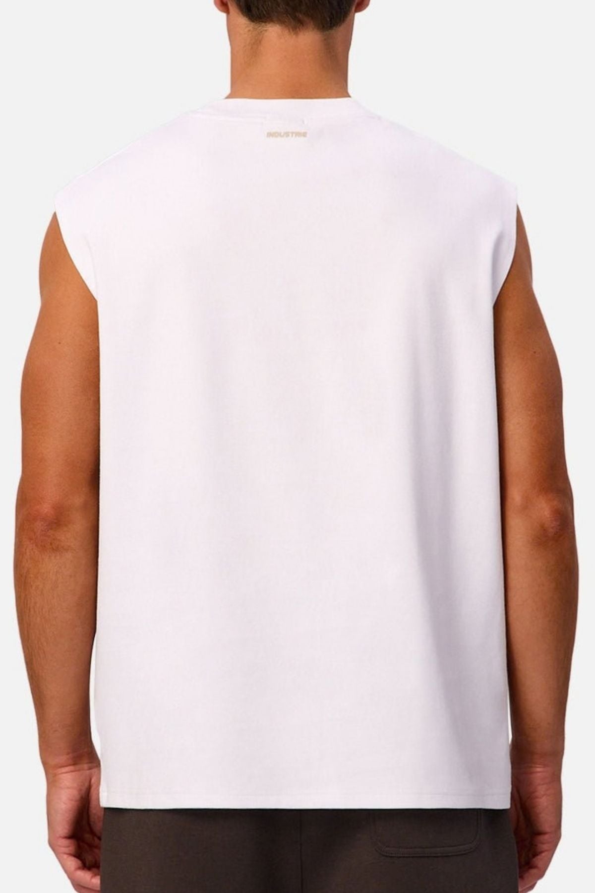 A person is shown from behind wearing the Industrie The Tech Port Sleeveless Tee in white with dark shorts against a plain light background.