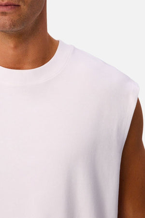 Close-up of a person wearing the Industrie The Tech Port Sleeveless Tee, showing part of their face, neck, shoulder, and upper arm against a plain background. This relaxed fit sleeveless tee is made from innovative tech fabric designed for superior comfort and breathability.