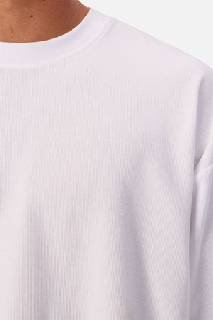 Close-up of a person wearing the Industrie The Waffle Long Sleeve Tee, showing only the neck, shoulder, and upper chest against a plain background.