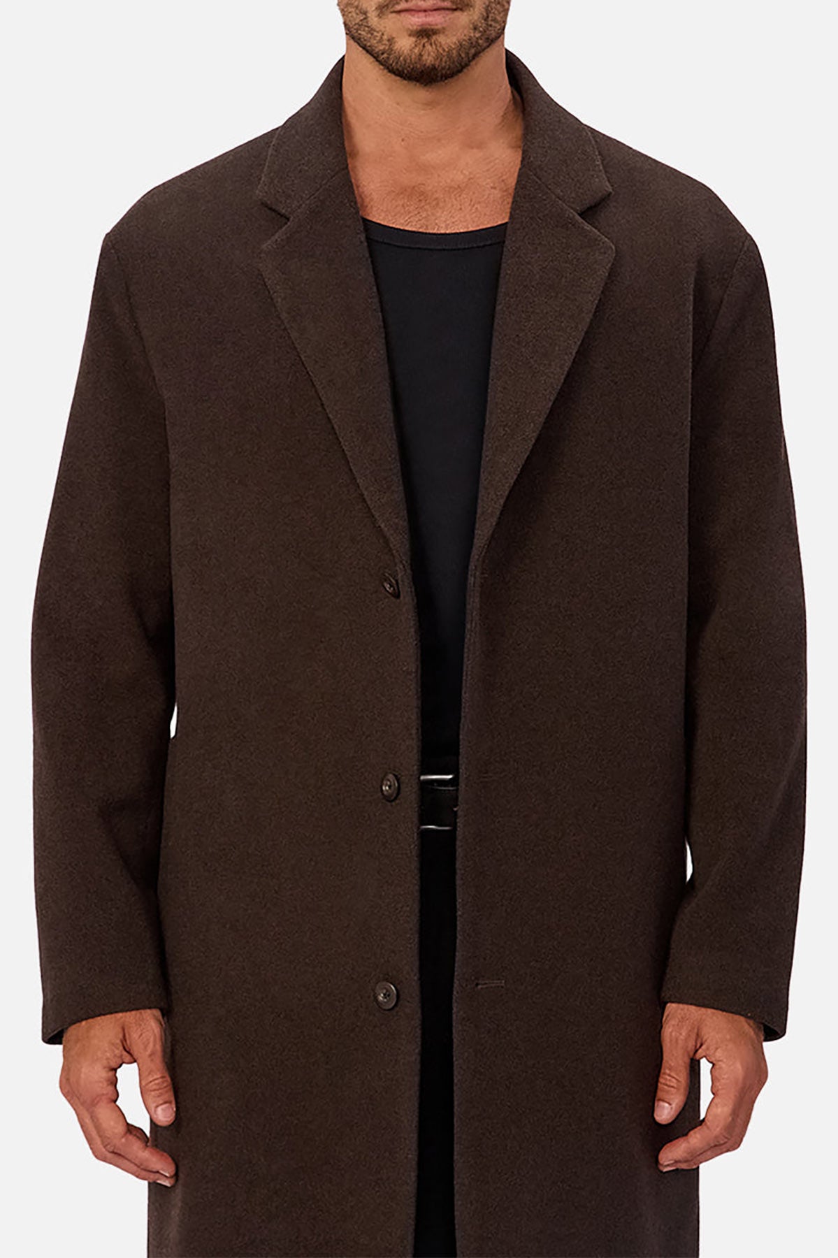 A man wearing the Industrie The Wool Blend Jacques Coat, a knee-length dark brown wool-blend piece with a structured fit and three buttons, over a black shirt against a plain light background. His face is partially cropped out.