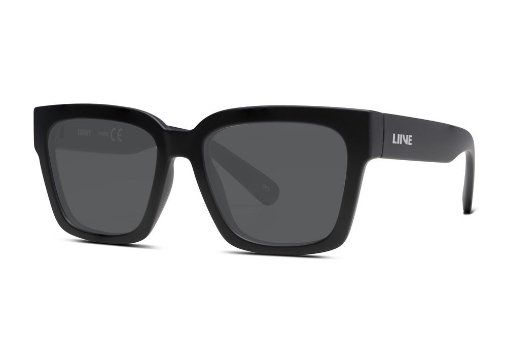 Liive Lenny Sunglasses feature black square frames with dark polycarbonate lenses and bold arms displaying the "Liive" brand name in white. These sunglasses offer essential UV protection, allowing kids to enjoy stylish sun safety and comfort.