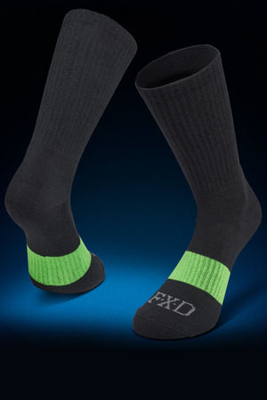 Five pairs of black FXD SK-6 Crew Socks, designed for work, are displayed on a blue gradient background. Each sock features a bright green band around the midfoot and "FXD" lettering on the toe area, while a padded foot bed provides all-day comfort and support.