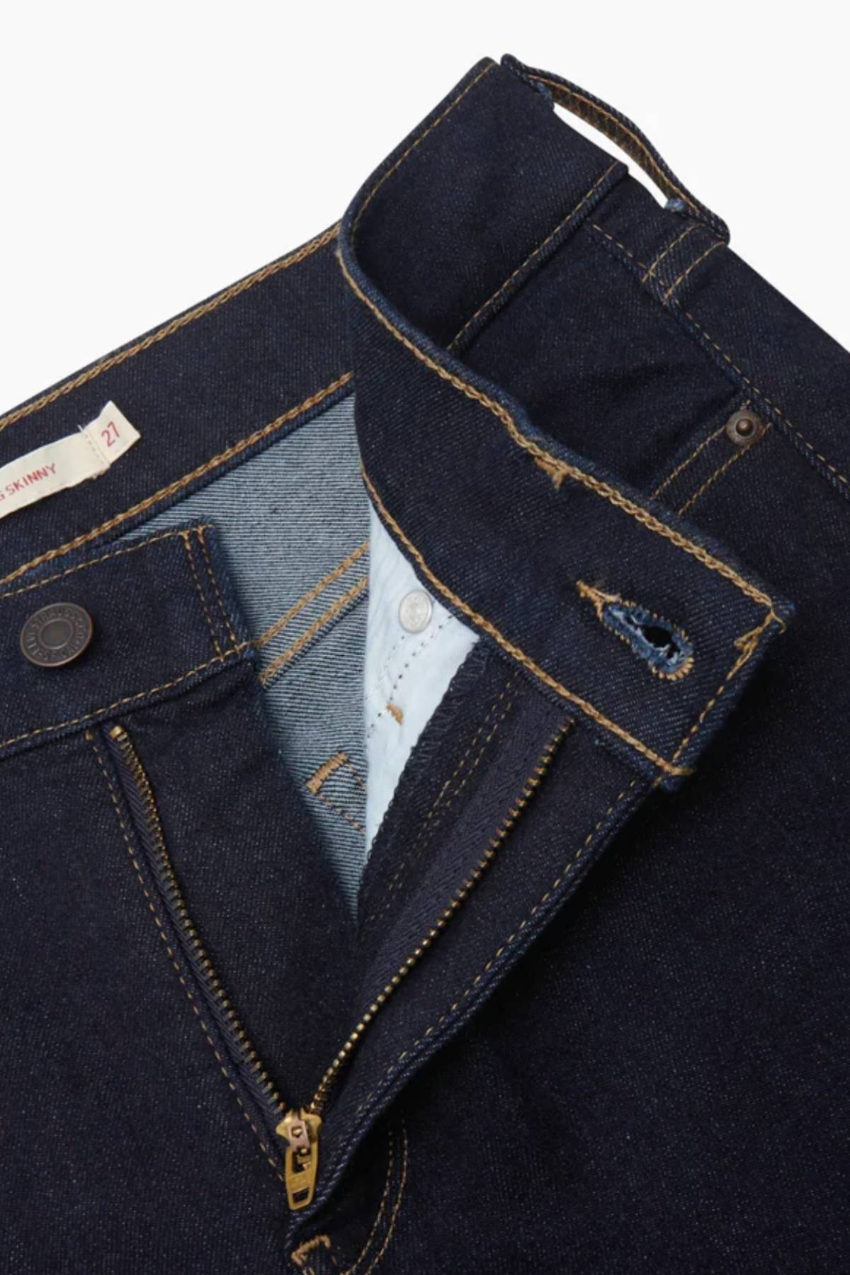 Close-up of Levis 311 Shaping Skinny Jean in dark blue, showing the partially open waistband, zipper, and button fly with a focus on inner fabric, stitching details, and subtle tummy control elements.