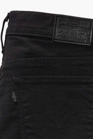 Close-up of black Levis 311 Shaping Skinny Jean showcasing a leather patch with embossed text on the waistband. Detailed stitching and a back pocket with a label enhance the garment, while a tummy panel discreetly offers comfortable support.