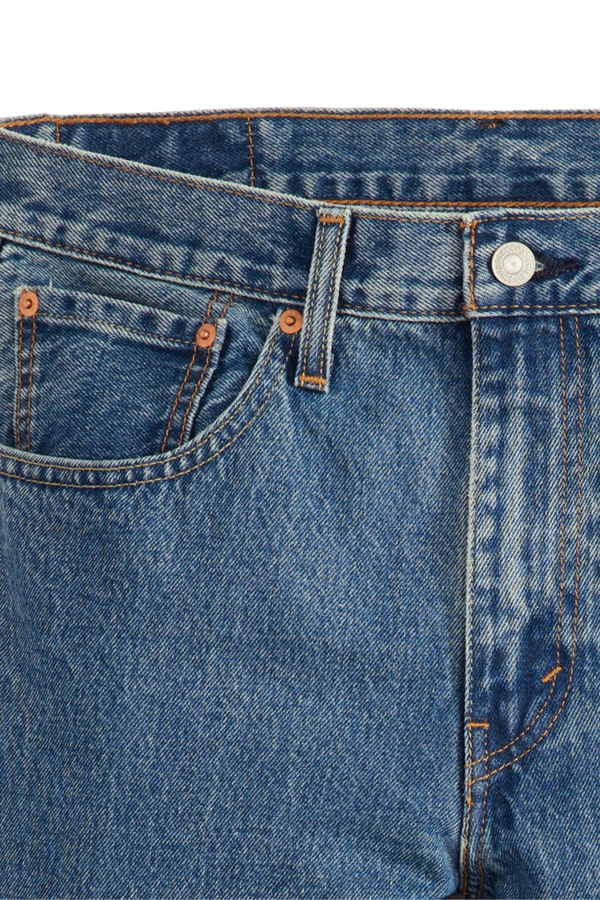 Close-up of the top part of Levis 516 Straight Jean in blue stonewash, highlighting the waistband, button, belt loop, front pocket, and orange stitching details.